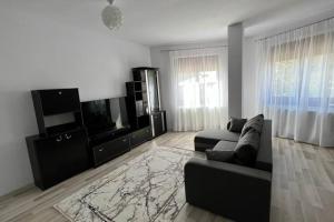 a living room with a couch and a flat screen tv at Alex 3 Apartament in Iaşi