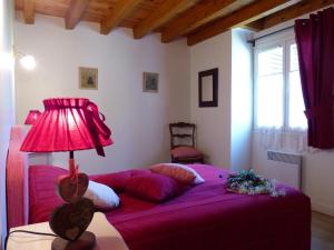 - une chambre avec un lit violet et une lampe dans l'établissement Gite d'Appy, aux Cabannes