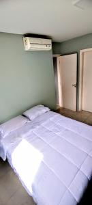 a bedroom with a large white bed in a room at Apartamento Aconchegante in Goiânia