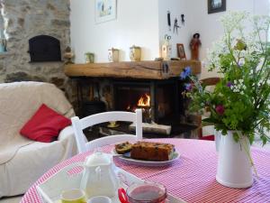 a table with a plate of cake and a fireplace at Gite d'Appy in Les Cabannes