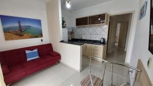 sala de estar con sofá rojo en la cocina en Apto 2 Quartos com Ar a 200m da Praia, en Florianópolis