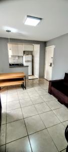 an empty room with a table and a kitchen at Apartamento Aconchegante in Goiânia