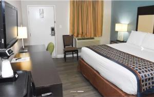 Una habitación de hotel con una cama y un escritorio con televisión. en Americas Best Value Inn Saint George, en Saint George