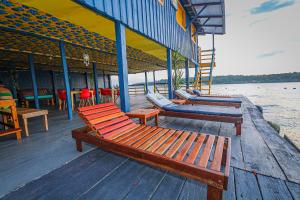 uma fila de bancos sentados numa doca junto à água em Abaré floating Lodge em Manaus