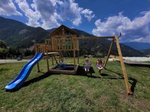 twee kinderen op een speelplaats met een glijbaan bij Pardellerhof Appartment Runcada in Luson