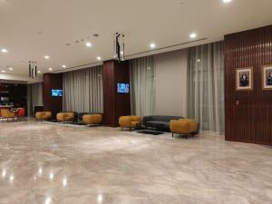um átrio com uma sala de espera com cadeiras e mesas em KYRIAD HOTEL SALALAH em Salalah