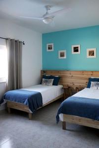 2 camas en una habitación con paredes azules en Quinta Ribeirinha - Lagos, en Bensafrim