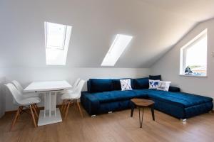 ein Wohnzimmer mit einem blauen Sofa und einem Tisch in der Unterkunft Ahoy Relax Apartmán Ocean in Nesvady