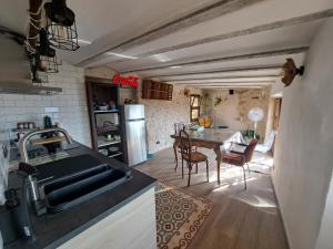 a kitchen with a sink and a table in a room at Ca la Maria in Lilla
