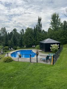 a fence around a swimming pool in a yard at Auberge Aux Deux Pères in Magog-Orford