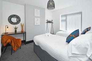 um quarto com 2 camas, uma secretária e um espelho. em Potter's Rest by YourStays em Stoke on Trent