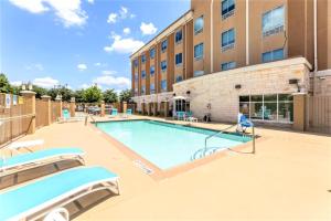Holiday Inn Express & Suites Houston East - Baytown, an IHG Hotel في باي تاون: مسبح امام مبنى