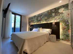 a bedroom with a large bed with a floral wall at El Serrat De Tregura in Vilallonga de Ter