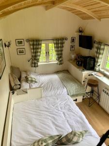 a bedroom with a bed and a desk with a computer at Beautiful Shepherd's Hut - Lois Weedon in Weston