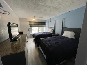 a room with two beds and a flat screen tv at Budgetel Chattanooga in Chattanooga