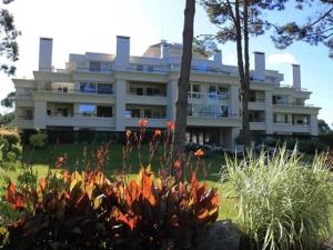 a large white building with a garden in front of it at Green Park penthouse 2 dormitorios in Punta del Este