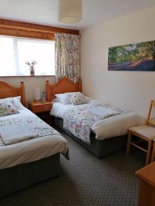 a hotel room with two beds and a window at Manorcombe No1, Callington Cornwall Pool view & prosseco in Callington