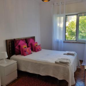 1 dormitorio con 1 cama grande con almohadas rosas en Sun House Belem -Free Paking and View Tower en Lisboa