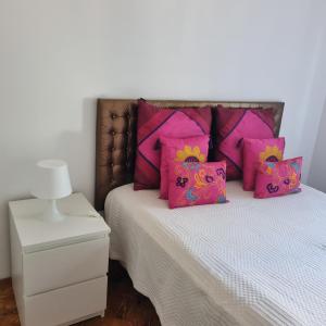 um quarto com uma cama com almofadas cor-de-rosa em Sun House Belem -Free Paking and View Tower em Lisboa