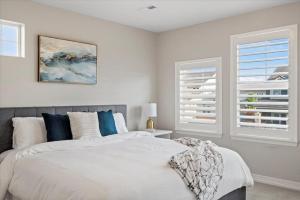 a bedroom with a white bed and two windows at The Retreat at Buffalo Run Golf Course - Commerce City in Henderson