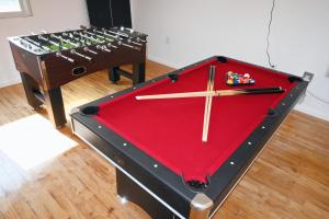 a snooker table with a red pool table at Modern Home in New Haven in Hamden