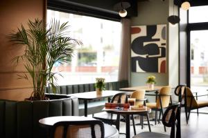 a restaurant with tables and chairs and a large window at Noa Hotel in Thessaloniki