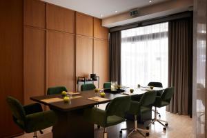 a conference room with a table and green chairs at Noa Hotel in Thessaloniki