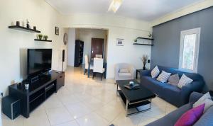 a living room with a couch and a tv at Apartment in Paiania near the airport in Paianía