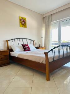 a bedroom with a large bed and a window at Apartment in Paiania near the airport in Paianía