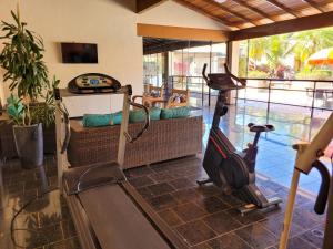 Habitación con gimnasio con cinta de correr y sofá en Hotel Pousada Parque das Águas en Olímpia