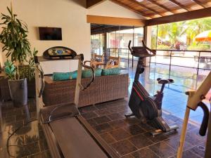 a room with a gym with a treadmill and a couch at Hotel Pousada Parque das Águas in Olímpia