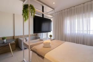 1 dormitorio con 1 cama y TV en la pared en Avenue Studio - GRU, en Guarulhos