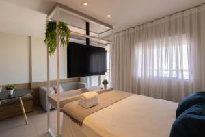 1 dormitorio con 1 cama y TV en la pared en Avenue Studio - GRU, en Guarulhos