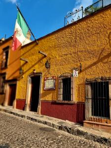 una bandera en un lado de un edificio amarillo en Hacienda de las Flores, en San Miguel de Allende