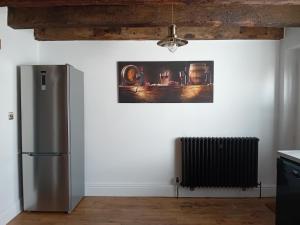 a kitchen with a refrigerator and a picture on the wall at SMUGGLERS HATCH in Marske-by-the-Sea