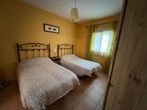 1 dormitorio con 2 camas y ventana en Finca Los Molinos, en La Alameda de Cervera