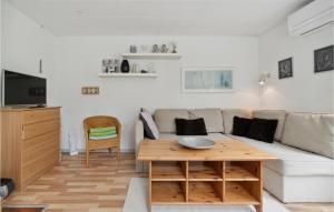 NeksøにあるNice Home In Nex With 2 Bedrooms And Wifiのリビングルーム(ソファ、テーブル付)