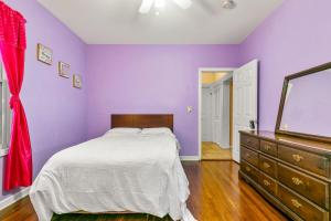 布里奇波特的住宿－The Pink Room near Yale Hospital/Bridegport，一间卧室设有紫色的墙壁、一张床和一个梳妆台