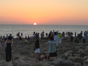 un grupo de personas en la playa mirando la puesta de sol en Apartamento Bellavista en Cala'n Bosch
