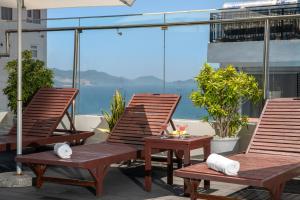 three chairs and a table on a balcony with the ocean at Sochi Hotel in Nha Trang