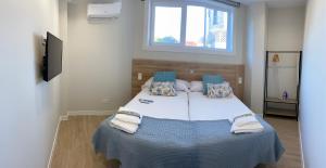 a bedroom with a large bed with towels on it at Apartamentos TARELA Porriño in Porriño