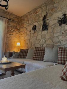a living room with a couch and a stone wall at Siviri Traditional Stone House in Siviri