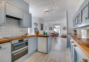 a kitchen with white cabinets and blue appliances at Pooh Corner in Praa Sands