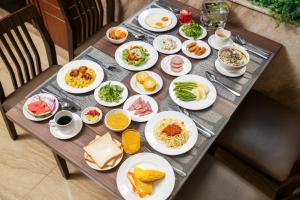 a table with many plates of food on it at Sochi Hotel in Nha Trang