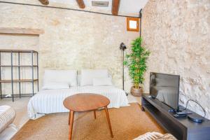 - un salon avec un lit et une télévision dans l'établissement Maison de charme 2 ch à Vauban proche Vieux Port, à Marseille