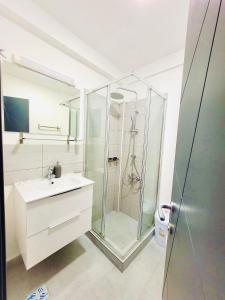 a bathroom with a glass shower and a sink at Laguna Grey in Mangalia