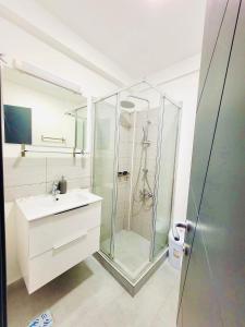 a bathroom with a glass shower and a sink at Laguna Grey in Mangalia +17 photos