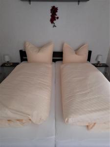 dos almohadas blancas sentadas en una cama en una habitación en Ferienwohnung Zawalla en Kamminke