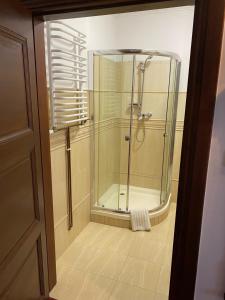 a shower with a glass door in a bathroom at Kanu Club - ośrodek wypoczynkowy in Nowy Zyzdrój +114 photos