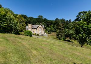 una casa grande en la cima de una colina con césped en The Retreat en Blackawton